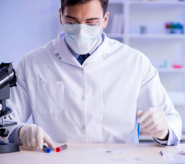 Laboratuvar asistanı hastanede kan örneklerini test ediyor.