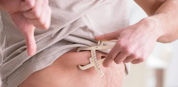 キャリパーで体脂肪を測定する男 — ストック写真