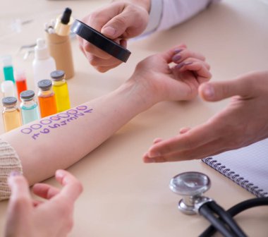 Hastanedeki hastanın alerji reaksiyonunu test eden doktor.