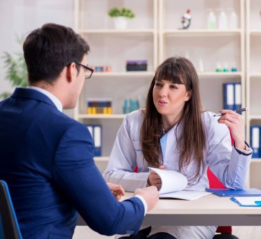 İş adamı doktorla sağlık sorunlarını tartışıyor