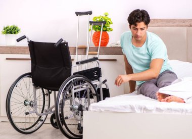 Genç yakışıklı engelli adam evde iyileşiyor.