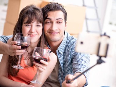 Bir çift selfie çekip şarap içiyor.