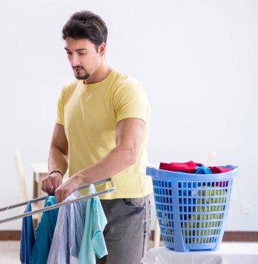 Yakışıklı koca evde çamaşır yıkıyor.