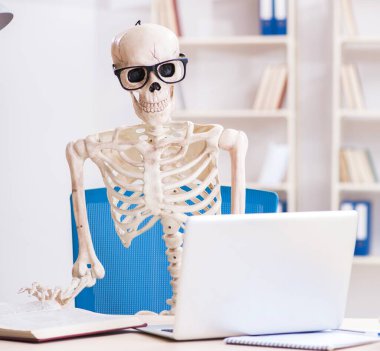 Ofiste çalışan iskelet işadamı.