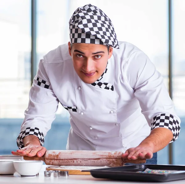 Young man cooking cookies in kitchen — Stock Photo, Image