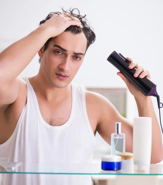 Jeune homme sèche ses cheveux le matin — Photo