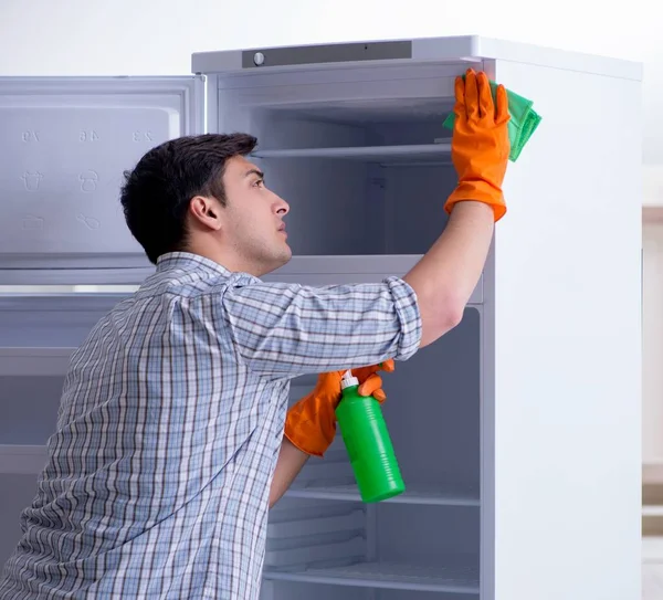Muž úklid lednice v hygienické koncepci — Stock fotografie