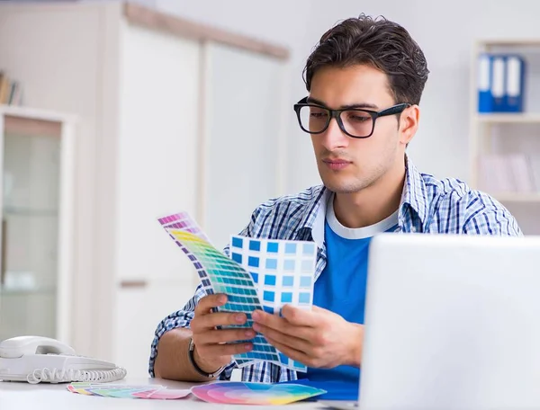 Joven diseñador trabajando en un nuevo proyecto y eligiendo colores —  Fotos de Stock