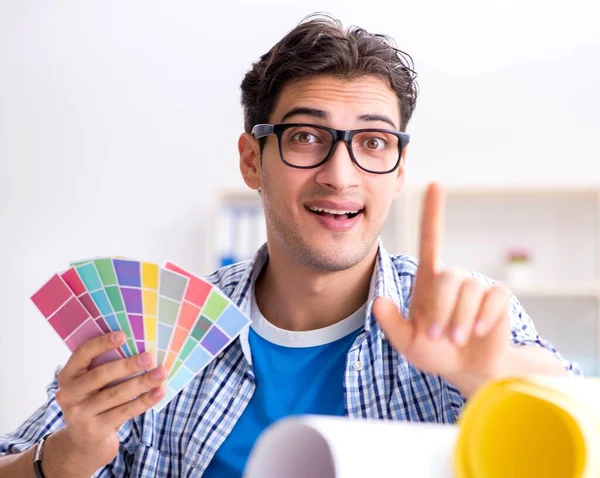 Joven diseñador trabajando en un nuevo proyecto y eligiendo colores — Foto de Stock