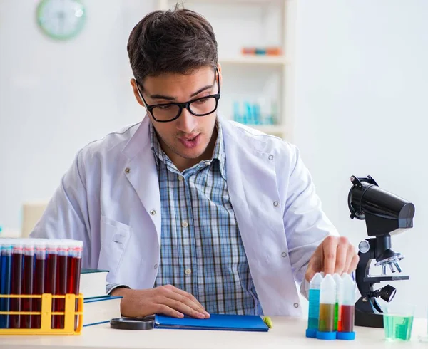 Joven estudiante de química trabajando en laboratorio sobre productos químicos — Foto de Stock