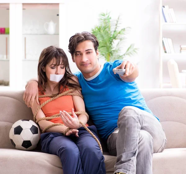 Muž svazuje svou ženu sledovat sportovní fotbal — Stock fotografie