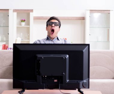 Evde 3D televizyon izleyen bir adam.