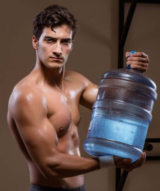 Büyük su şişeli kaslı adam.