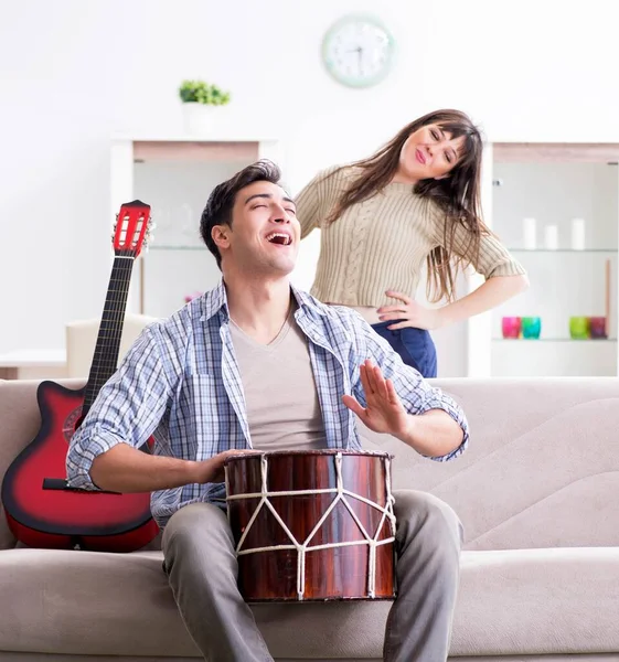 Família jovem cantando e tocando música em casa — Fotografia de Stock