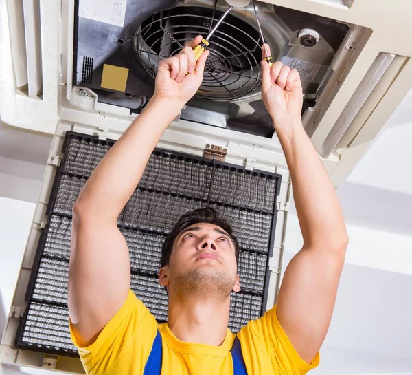 Reparador reparando la unidad de aire acondicionado del techo — Foto de Stock