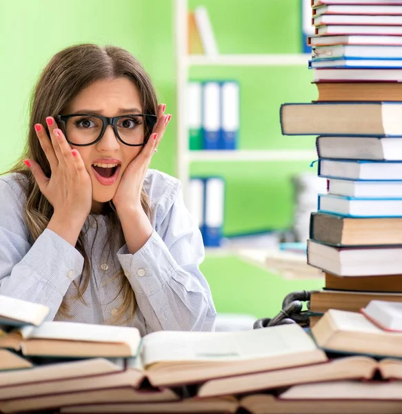 Jonge vrouwelijke student bereidt zich voor op examens met veel boeken — Stockfoto