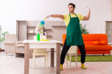 Genç müteahhit evin içini temizliyor.