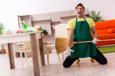 Genç müteahhit evin içini temizliyor.