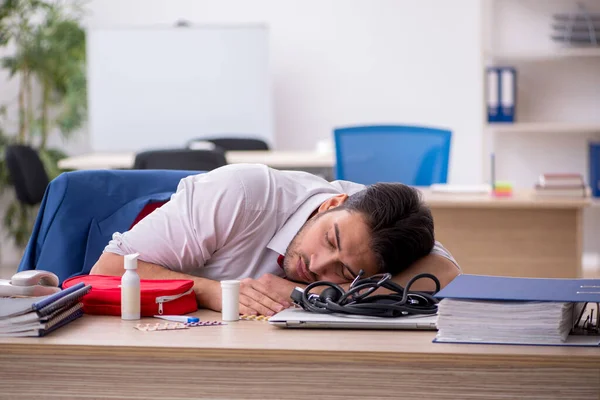 Joven empleado masculino que sufre en el lugar de trabajo — Foto de Stock