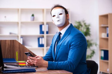 Ofiste maske takan genç bir erkek.