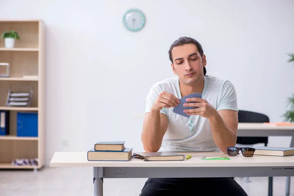 Fiatal férfi diák kártyázik a vizsga előkészítése során a — Stock Fotó