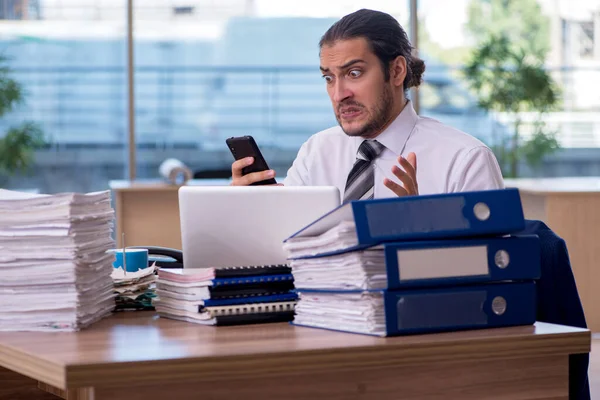 Giovane dipendente maschio infelice con un lavoro eccessivo in ufficio — Foto Stock