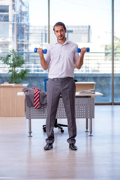 Junge männliche Angestellte beim Sport im Büro — Stockfoto