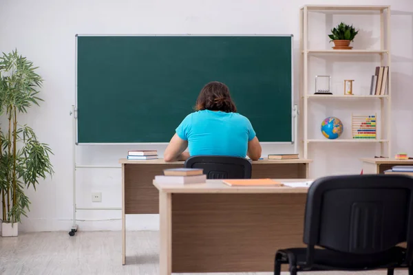 Jonge mannelijke student voor het groene bord — Stockfoto