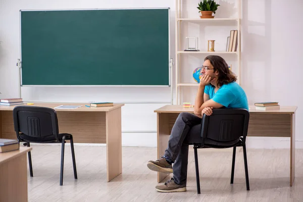 Young male student in front of green board — Stock Photo, Image