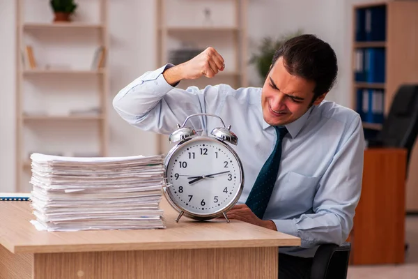 Joven empleado masculino en concepto de gestión del tiempo — Foto de Stock