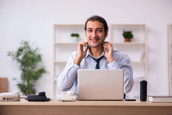 Jovem operador de call center do sexo masculino trabalhando em sua mesa — Fotografia de Stock