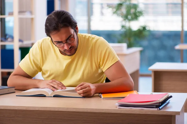 Giovane studente maschio che si prepara per gli esami in classe — Foto Stock