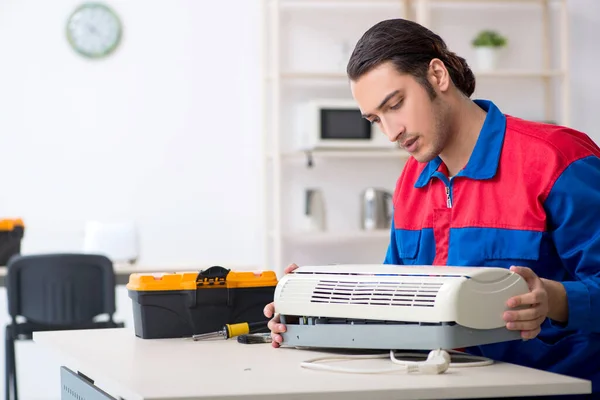 Young repairman repairing air-conditioner at warranty center — Stock Photo, Image