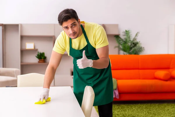 Jovem empreiteiro limpando a casa dentro de casa — Fotografia de Stock