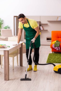 Genç müteahhit evin içini temizliyor.