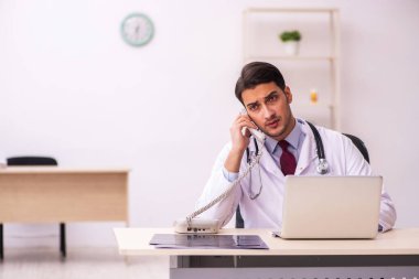 Klinikte çalışan genç erkek doktor.