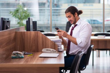 Genç bir erkek işçi ve ofiste çok fazla iş var.