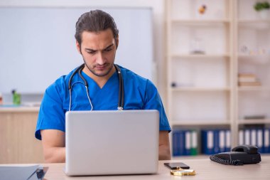 Klinikte çalışan genç erkek doktor.