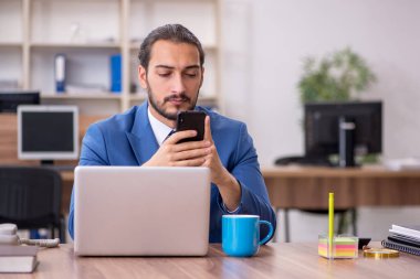 Ofiste çalışan genç bir erkek.