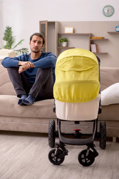 Jovem empreiteiro masculino cuidando do bebê em casa — Fotografia de Stock