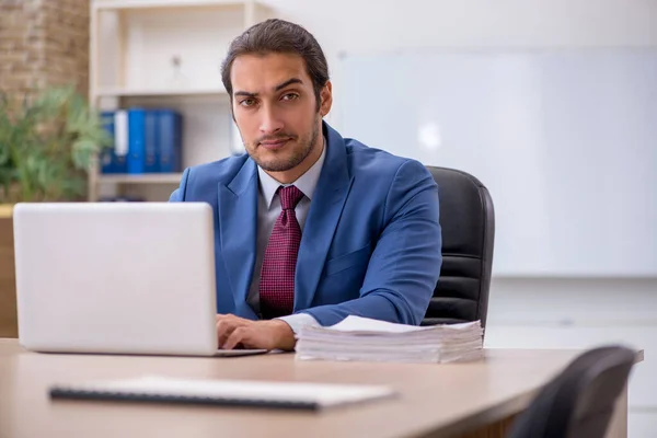 Jeune employé masculin assis dans le bureau devant le tableau blanc — Photo