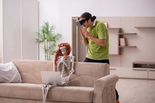 Young man with female skeleton in virtual reality concept