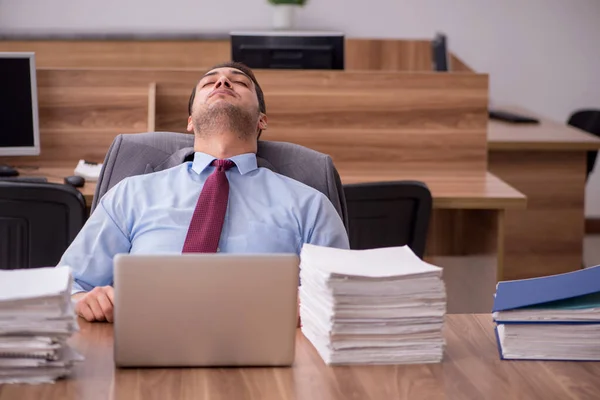 Jovem funcionário masculino infeliz com excesso de trabalho no escritório — Fotografia de Stock