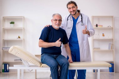 Yaşlı erkek hasta genç erkek doktoru ziyaret ediyor.