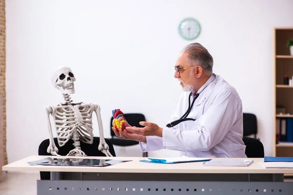 Klinikteki yaşlı erkek kardiyolog ve iskelet hastası. — Stok fotoğraf