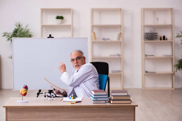Old male doctor cardiologist sitting in the classroom — Stock Photo, Image