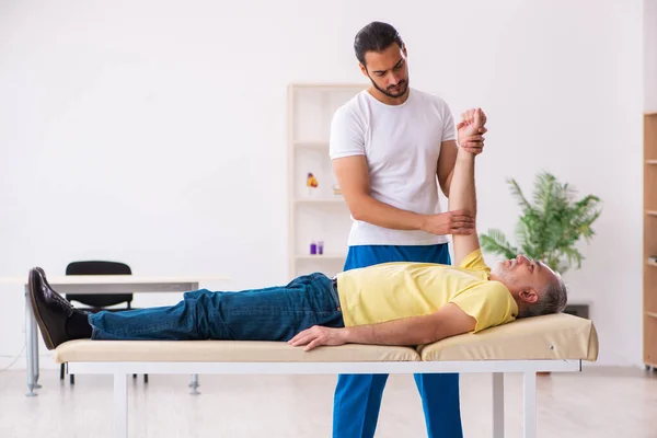 Alt männlich patient besuch jung männlich arzt chiropraktiker — Stockfoto