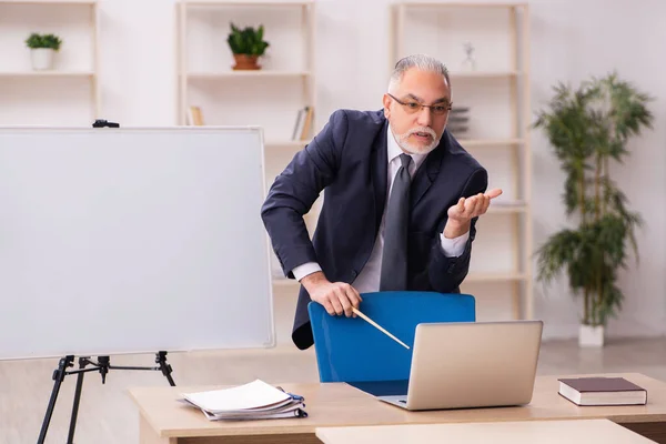 Old male employer in front of white board — Stock Photo, Image