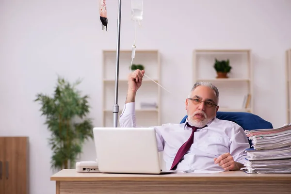 Oude mannelijke werknemer in het concept bloedtransfusie — Stockfoto