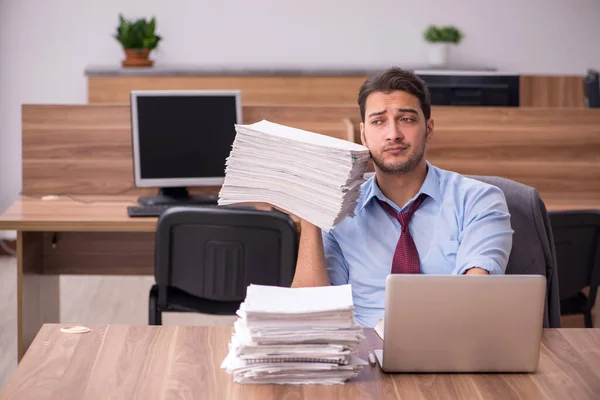 Młody mężczyzna pracownik niezadowolony z nadmiernej pracy w biurze — Zdjęcie stockowe
